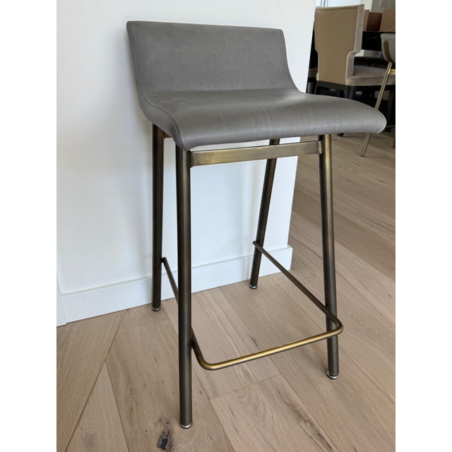 A sophisticated set of three “Gachot” counter stools by Thomas Hayes, featuring sleek architectural lines, supple...