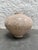 Ovoid Raku Fire glaze vase with an incised signature on the bottom. The color of the vase is a creamy pink with gray...