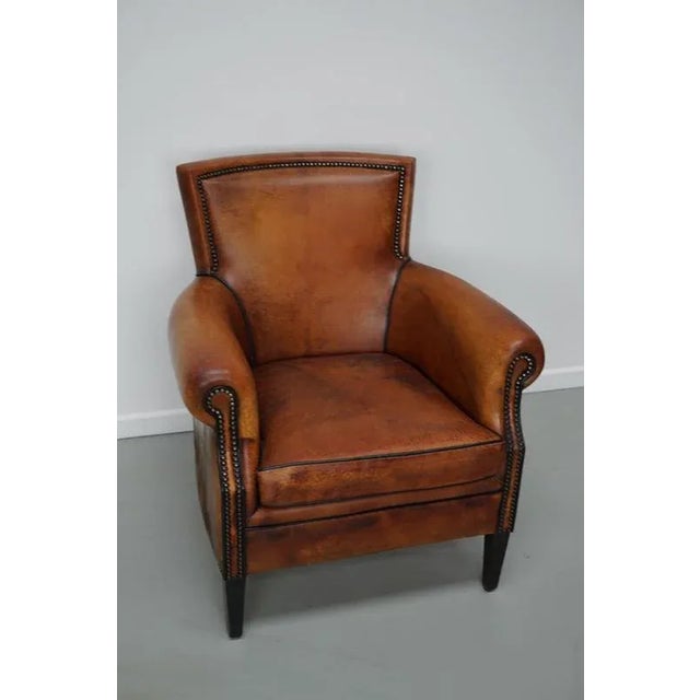 This cognac-colored leather club chair comes from the Netherlands. It is upholstered with cognac-colored leather and...