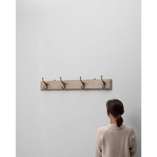 This 1900s French wooden wall hanger offers simple, functional charm with a subtly patinated finish that showcases the...