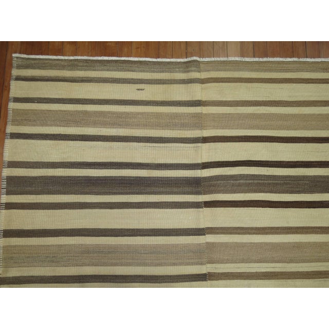 A vintage turkish kilim with a striped motif in browns and cream. 5'1'' x 9'9''