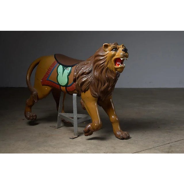 Behold this majestic antique carousel figure featuring a regal lion. Meticulously hand-carved from wood and mounted on a...