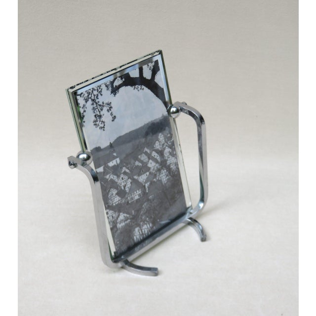 A delicate picture frame in the austere Art Deco style, made in France in the 1920s or 30s. The two glass panes are held...
