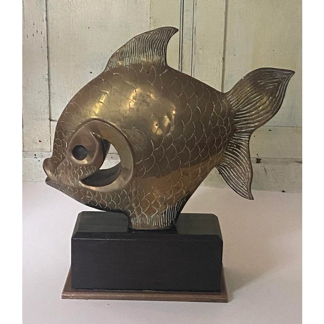 Art Deco style bronze or brass swimming fish sculpture on a wooden base. Bronze trim on the bottom of the wooden base....