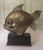 Art Deco style bronze or brass swimming fish sculpture on a wooden base. Bronze trim on the bottom of the wooden base....