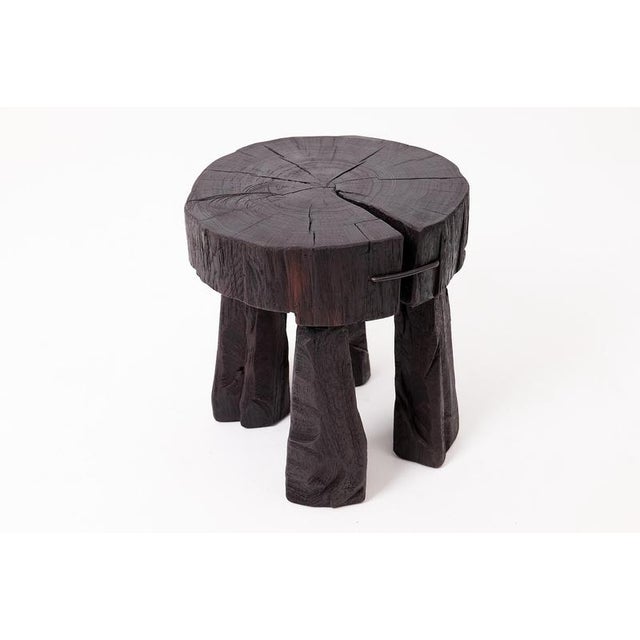 This commanding functional sculpture is hand-carved from a single, massive hardwood log. It features a substantial, thick...