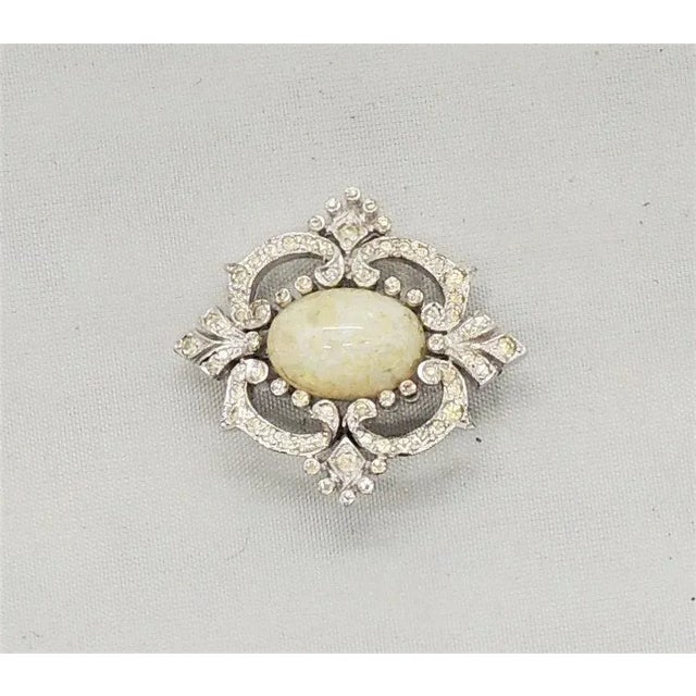 This is part of Chairish’s Costume Jewelry assortment. Circa 1960s rhodium plated cabochon faux-opal with small round...