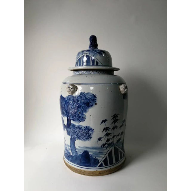 This blue and white porcelain jar is adorned with hand painted ever green and plum flowers. The lid has a small foo dog on...