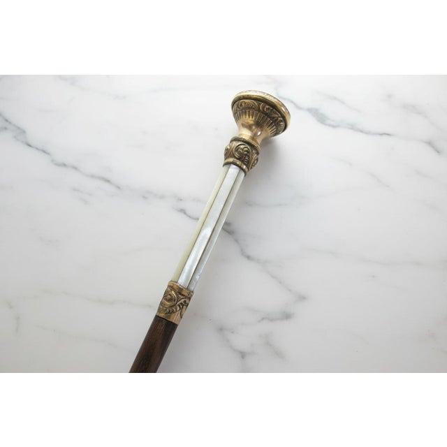 Victorian era wood walking stick cane with mother of pearl and brass detail. Handle is accented with a mother-of-pearl...