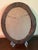 This painting, signed by L S Weeks, is an oil on board. It is undated. The classic oval frame measures 18"H x 14"W. The...