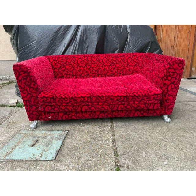 The Monster Sofa by Bretz is upholstered in red fabric and stands on silver feet. The three -seater is characterized by...