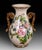 This handcrafted Italian ceramic vase features an elegant hand-painted rose motif in soft pink and ivory tones, framed by...