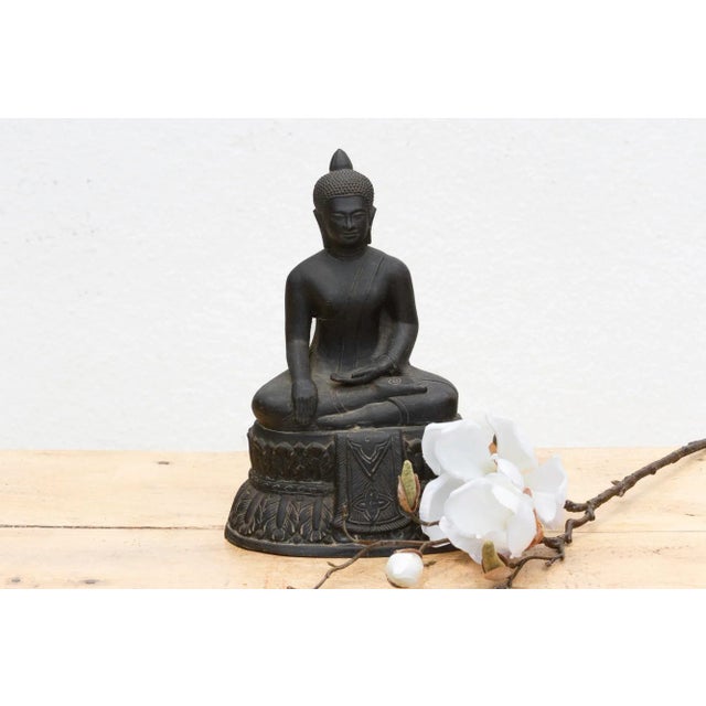 This captivating patinated Buddha figure, measuring 8 inches wide, 5 inches deep, and 11 inches high, embodies profound...