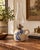 Charming antique stoneware oil lamp featuring a rounded cream ceramic body with hand-painted cobalt blue floral decoration...