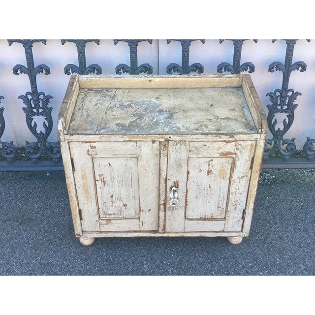 Like a bucket bench with doors, this little utilitarian cupboard, with a 2” high gallery around its top edge, would have...