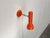 Minimalist wall lights from swisslamps in a unique color. a simple design in a striking orange hue. The light head...