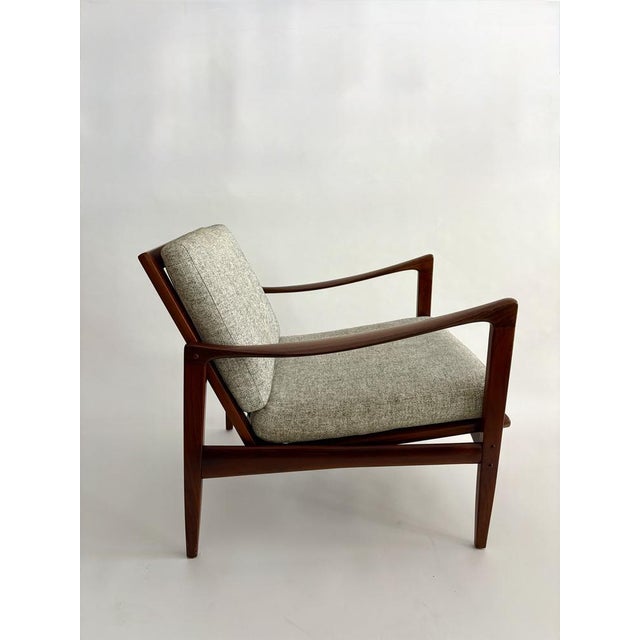 An elegant pair of "candidate" armchairs designed by ibkofod-larsen and crafted from solid afrormosia (african teak) for...