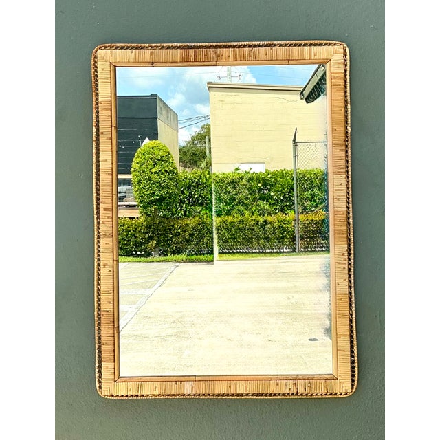 This vintage mid-century wall mirror celebrates the enduring beauty of natural materials through its expertly woven rattan...