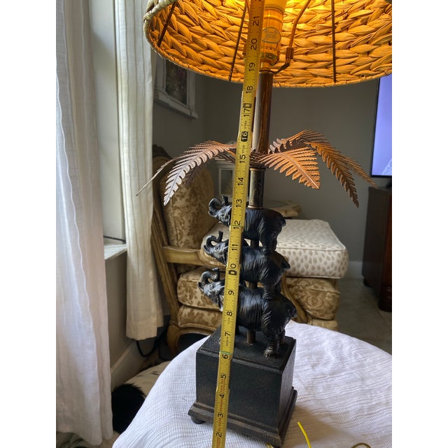 a vintage-style stacked elephant palm tree table lamp. This distinctive piece of home decor features a dark bronze or...