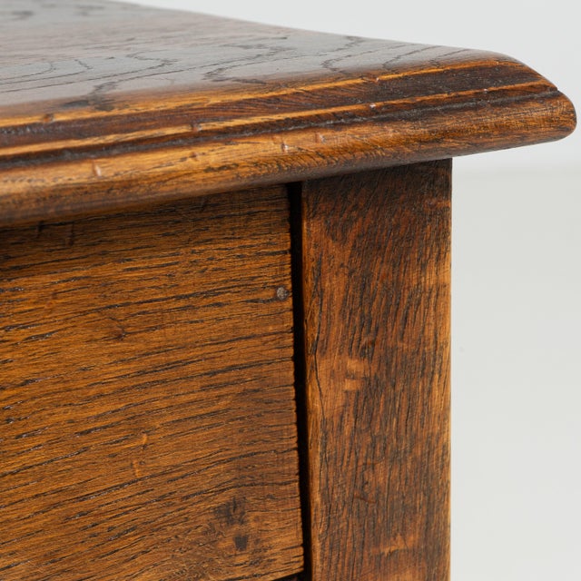A circa 1970 French side table crafted in oak, featuring a rectangular top above a simple frame with lower shelf and...