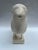 A single contemporary sculpture of a sheep mounted on a rectangular base with chalky white finish.
