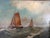 A compelling vintage oil painting on board depicting traditional sailing vessels navigating choppy coastal waters beneath...