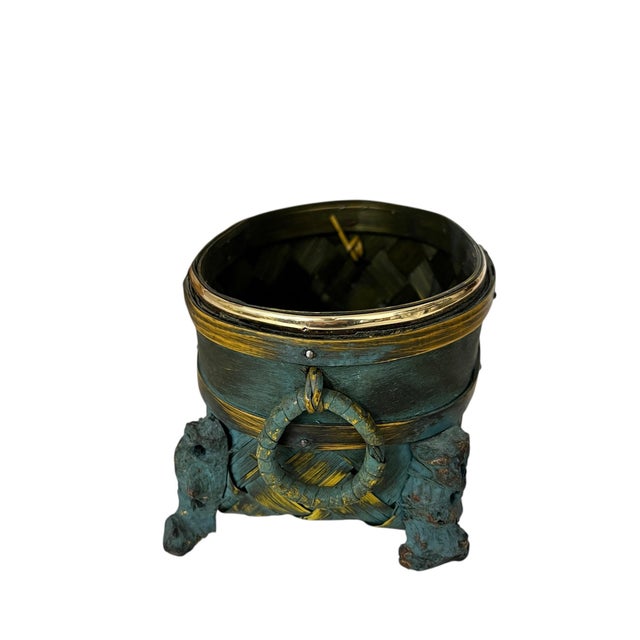 Vintage chinoiserie footed basket with brass rim, round knockers on each end and carved wooded feet. Finished out with a...