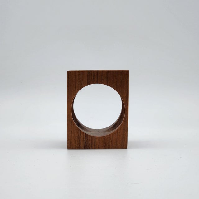 Scandinavian modern teak cube candle holder with circular cutouts on each face, creating a sculptural open-form...