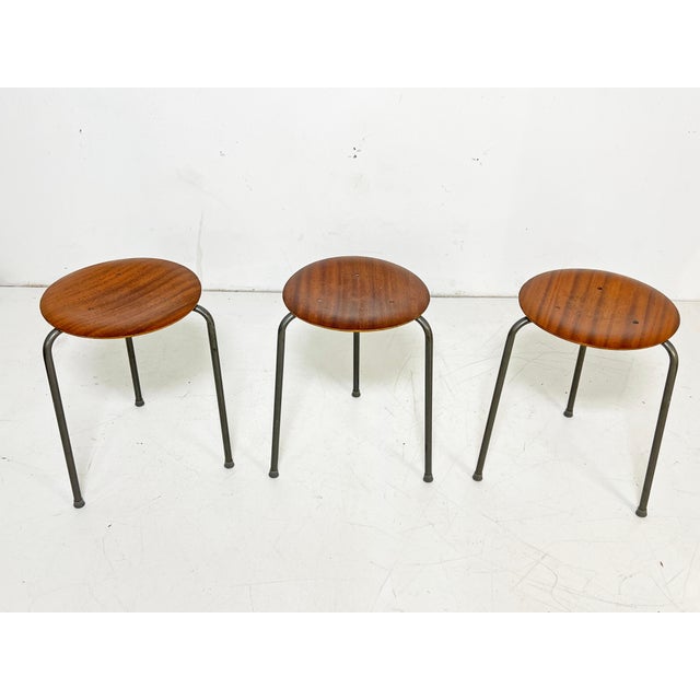 Set of three Danish teak bentwood "dot" stools with tripod legs, designed by Arne Jacobsen, circa 1960s. Seat diameter is...
