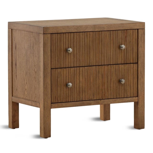 Warm oak nightstand with two carved drawers in a narrow zig-zag texture. Antiqued nickel finish drawer knobs. Each...