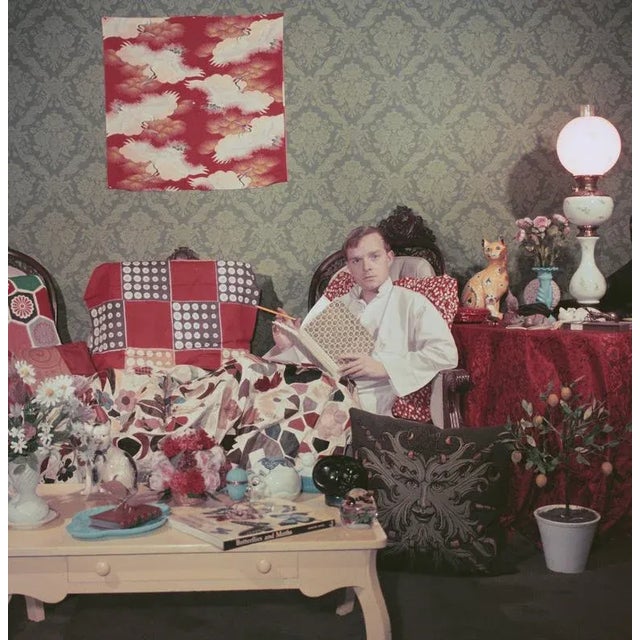 Capote at Home 1958 Author Truman Capote (1924 – 1984) relaxes with a book and a cigarette in his cluttered apartment,...