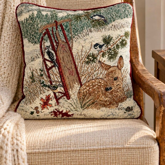 Beautiful winter woodland tapestry pillow featuring the artwork of Joseph Giordano, with a resting fawn nestled in the...