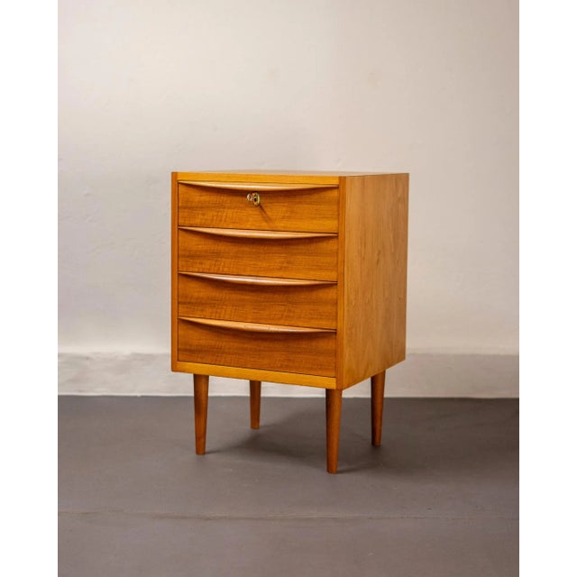 Small German chest of drawers in walnut and teak veneer. Mid-century design with four drawers, solid teak handles, and...