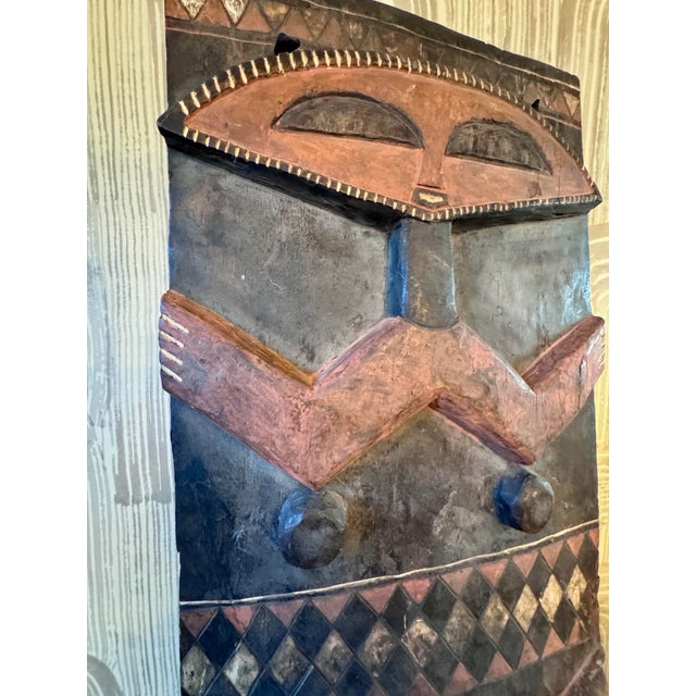 A dramatic carved and polychromed wood figural panel attributed to the Pende artistic tradition of the Democratic Republic...