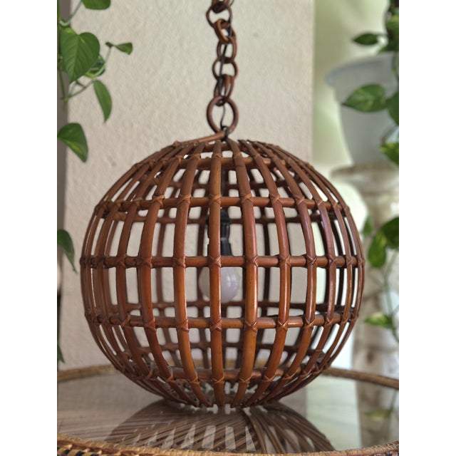 An exceptional mid-20th-century Italian ceiling lamp, crafted entirely from hand-worked natural wicker, with a perfectly...