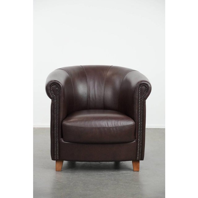 We are offering this English-style cowhide club armchair in excellent condition, featuring a brown/dark purple color...