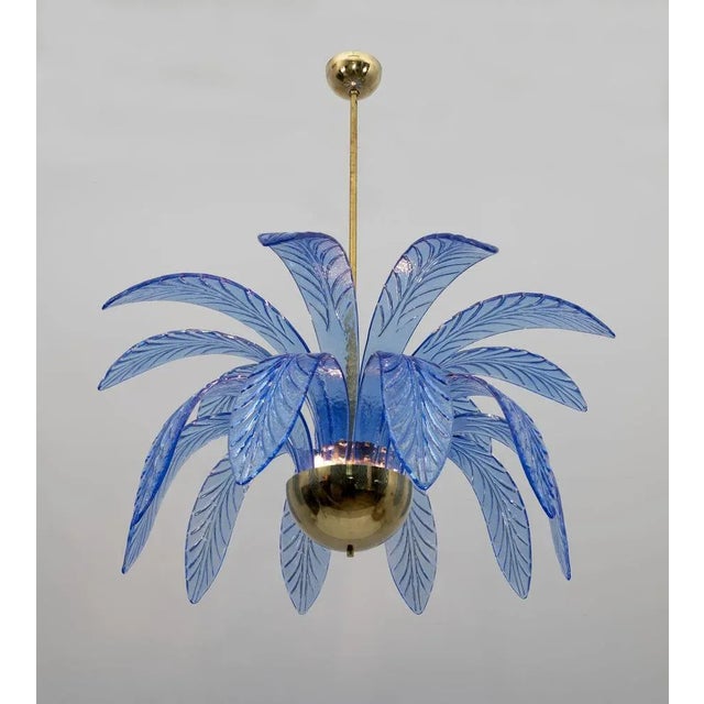Mouth-blown murano glass chandelier, light blue murano glass leaves, brass structure, three light bulbs. The chandelier...