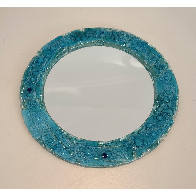 This beautiful decorative mirror features a round, blue-tinted glass frame. It is a French piece. Circa 1970