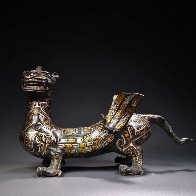 This is a striking cast bronze figurine of a winged mythical beast, featuring elaborate gold and silver inlay (gilt...