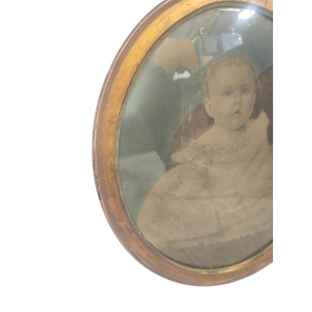 Antique oval portrait of a young child, circa 1890–1910. This charming piece features a hand-tinted photographic portrait...