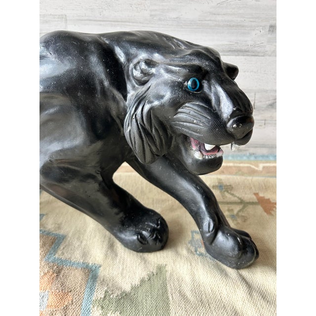 Vintage black panther sculpture. black with acrylic blue eyes and a painted mouth. Large and heavy.