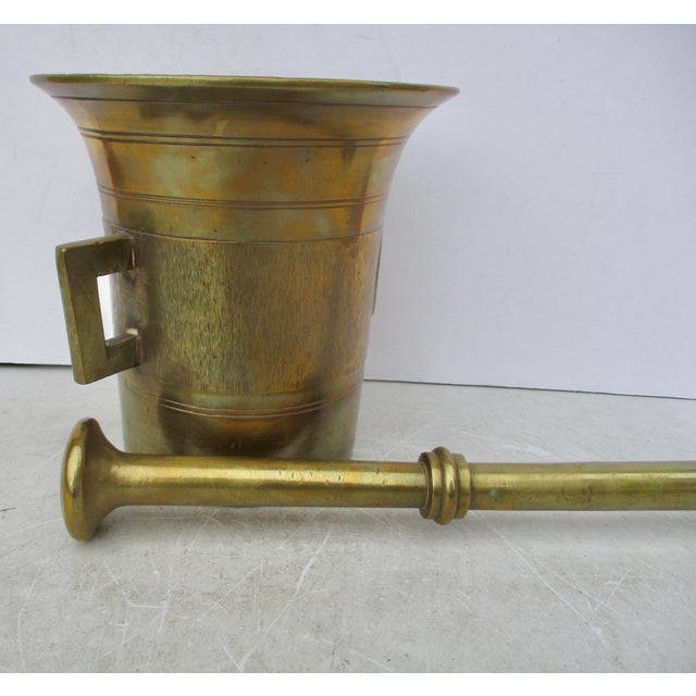 Antique early 20th-century bronze mortar and pestle. Heavy and large grinding vessel. Textured outside walls and ringed...