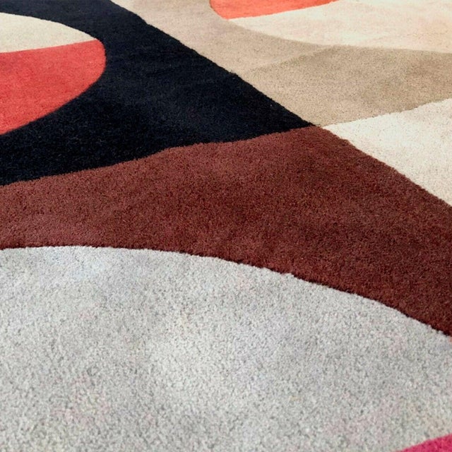 A wall hanging with shifting, colorful patterns, creating a kinetic effect through the arrangement of hues. Produced by...