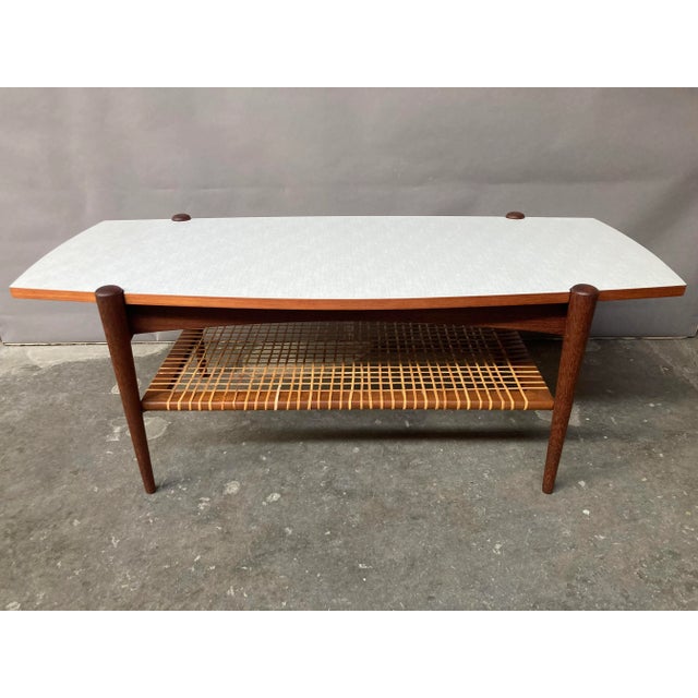 Mid-Century teak coffee table designed by Louis Van Teeffelen for Dutch manufacturer WéBé in the 50s, with a magazine rack...