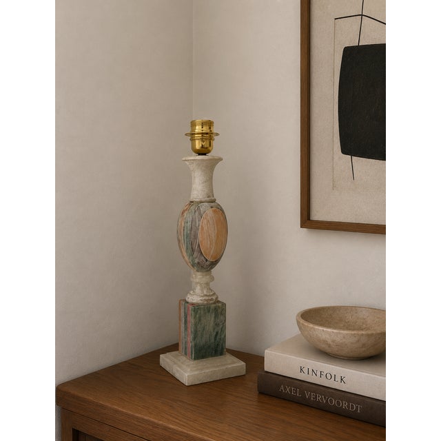 The alabaster lamp features a slender and elegant shape, with a tapered base reminiscent of a contemporary obelisk. The...
