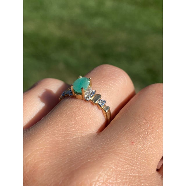 The Gastonia: Ladies Yellow Gold Ring set with Emerald and Diamonds. Crafted in yellow gold, this ladies' cocktail ring...