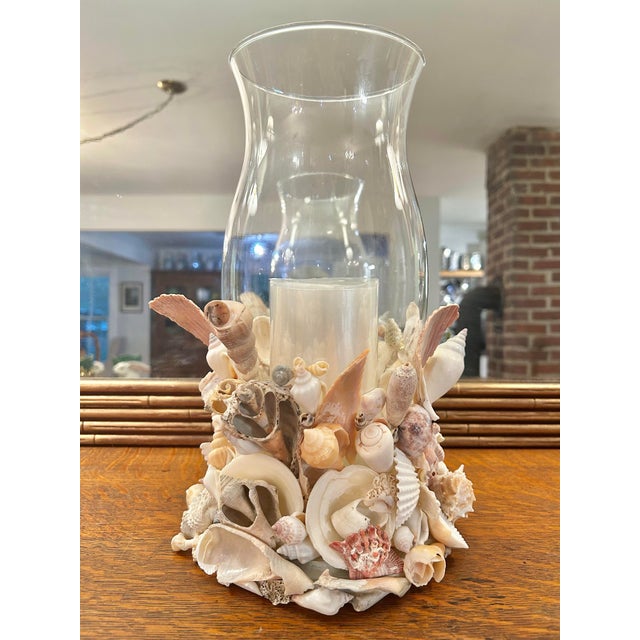 This handcrafted coastal hurricane candle holder is lavishly embellished with an organic collection of natural seashells...