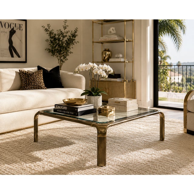 A sleek and substantial brass and glass coffee table attributed to Mastercraft, possibly from their collaboration with...