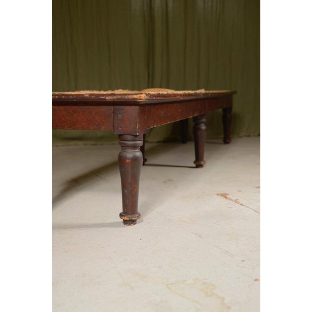 A good Victorian long footstool, in the original crusty stained pine finish, on six turned legs. For re-webbing and...