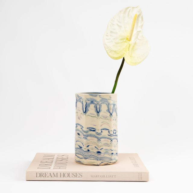 Cylindrical ceramic vase crafted in the Nerikomi marbling technique, with swirling veins of blue, green, and pink set...